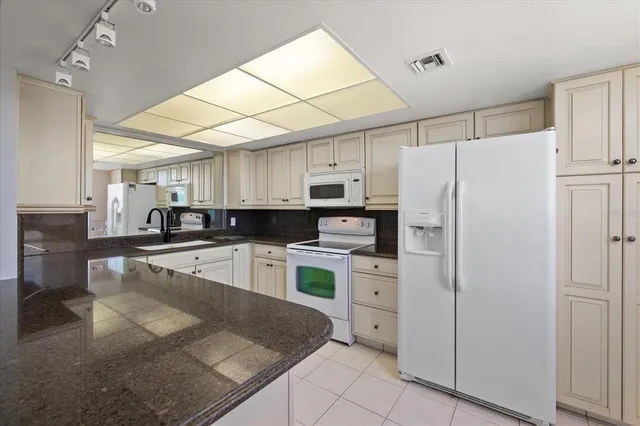 a kitchen with white cabinets and white appliances