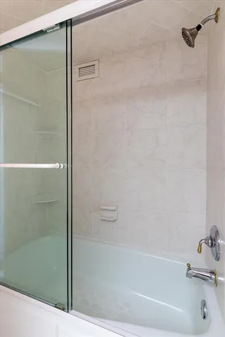 a bathroom with a glass shower door