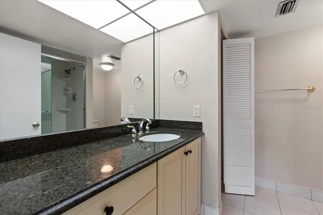 a bathroom with a granite countertop sink and a mirror