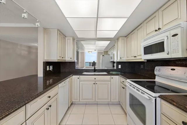 a kitchen with white cabinets sink and white appliances