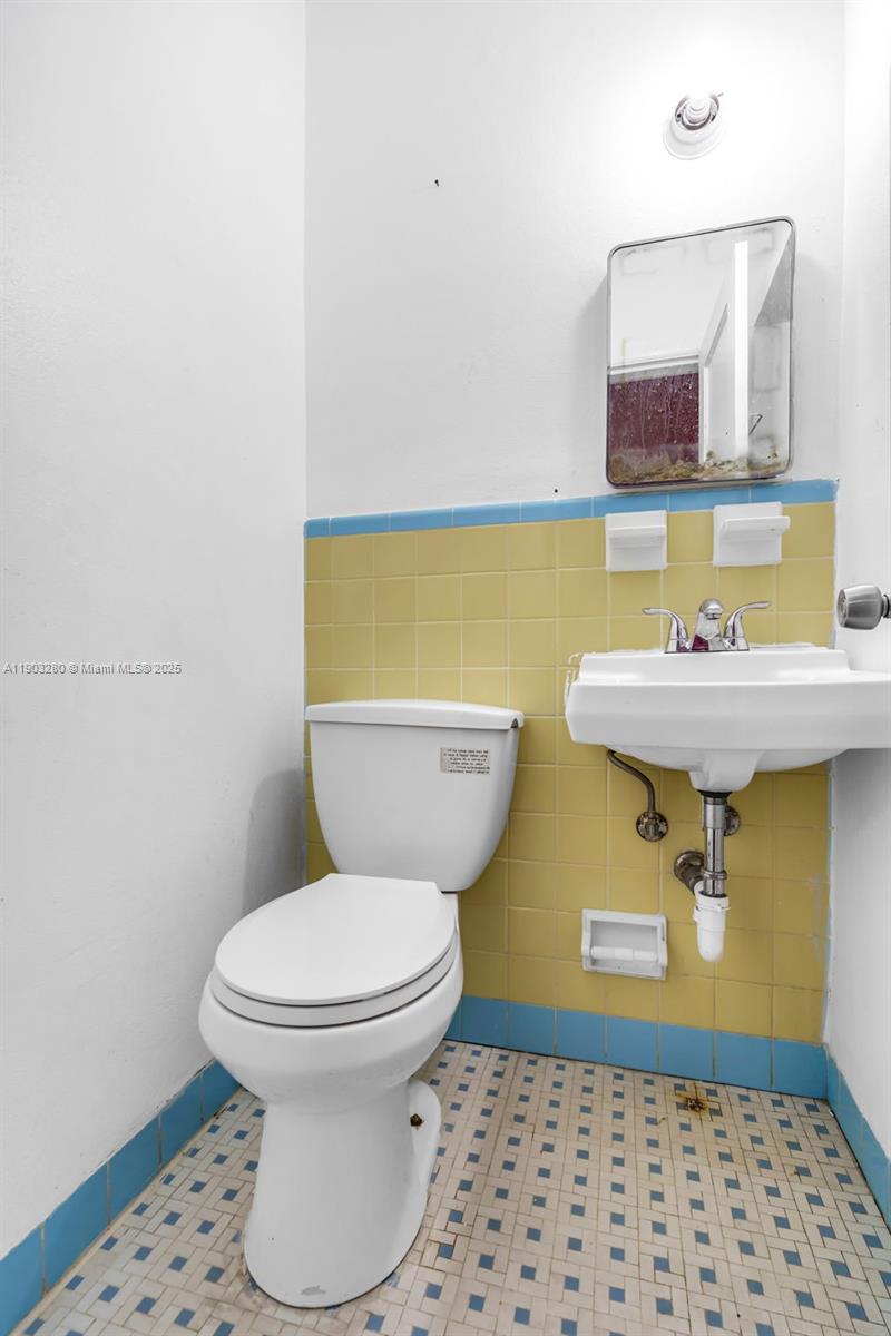 175 West 56th Street Hialeah, FL 33012 - Photo 18 of 39 a bathroom with a sink toilet and mirror