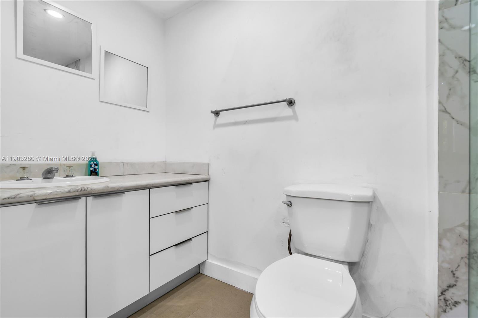 175 West 56th Street Hialeah, FL 33012 - Photo 21 of 39 a bathroom with a toilet sink and mirror