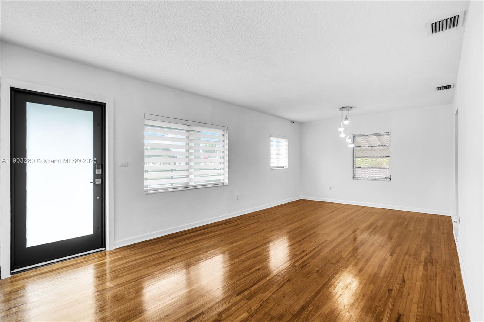 175 West 56th Street Hialeah, FL 33012 - Photo 5 of 39 a view of an empty room with wooden floor and a window