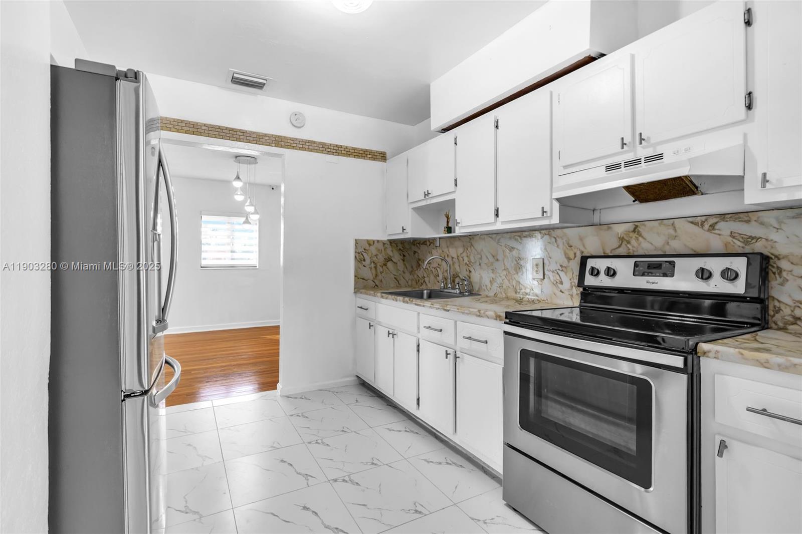 175 West 56th Street Hialeah, FL 33012 - Photo 9 of 39 a kitchen with granite countertop white cabinets stainless steel appliances and sink