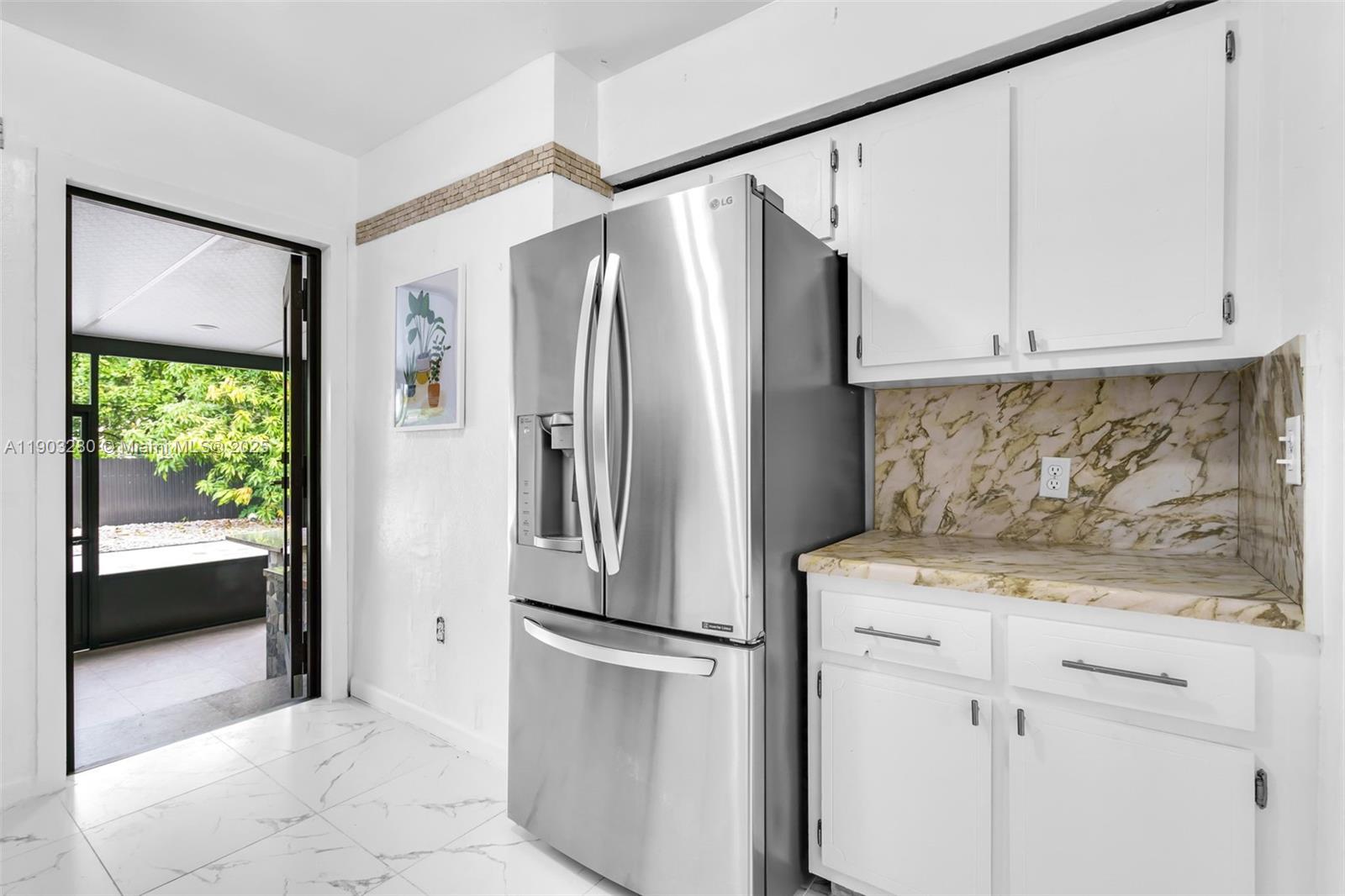175 West 56th Street Hialeah, FL 33012 - Photo 10 of 39 a kitchen with a refrigerator a sink and cabinets