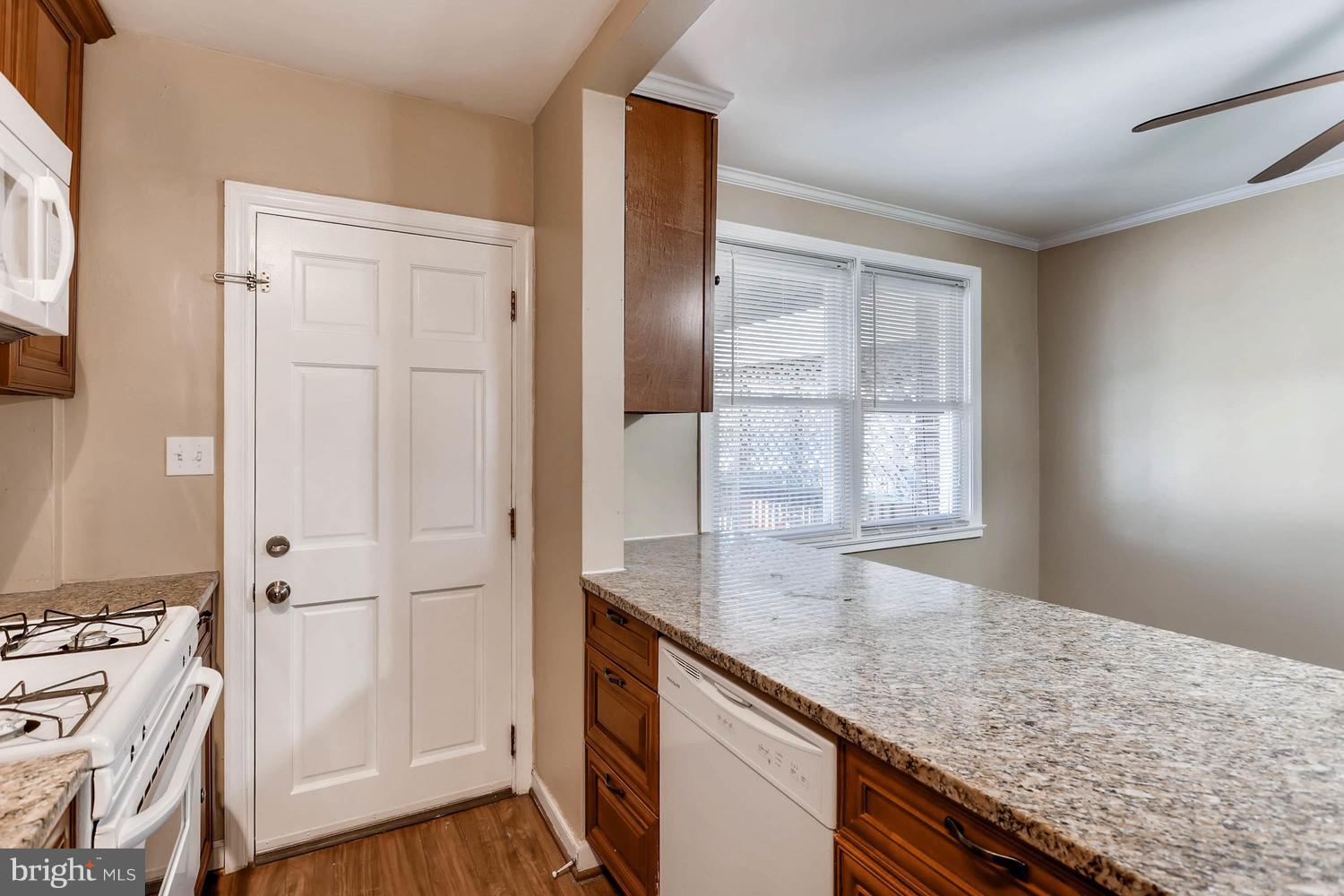 7530 Westfield Road Baltimore, MD 21222 - Photo 11 of 30 a hallway with granite countertop white cabinets and wooden floor