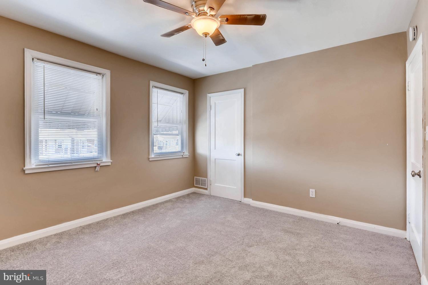 7530 Westfield Road Baltimore, MD 21222 - Photo 16 of 30 an empty room with chandelier fan and windows