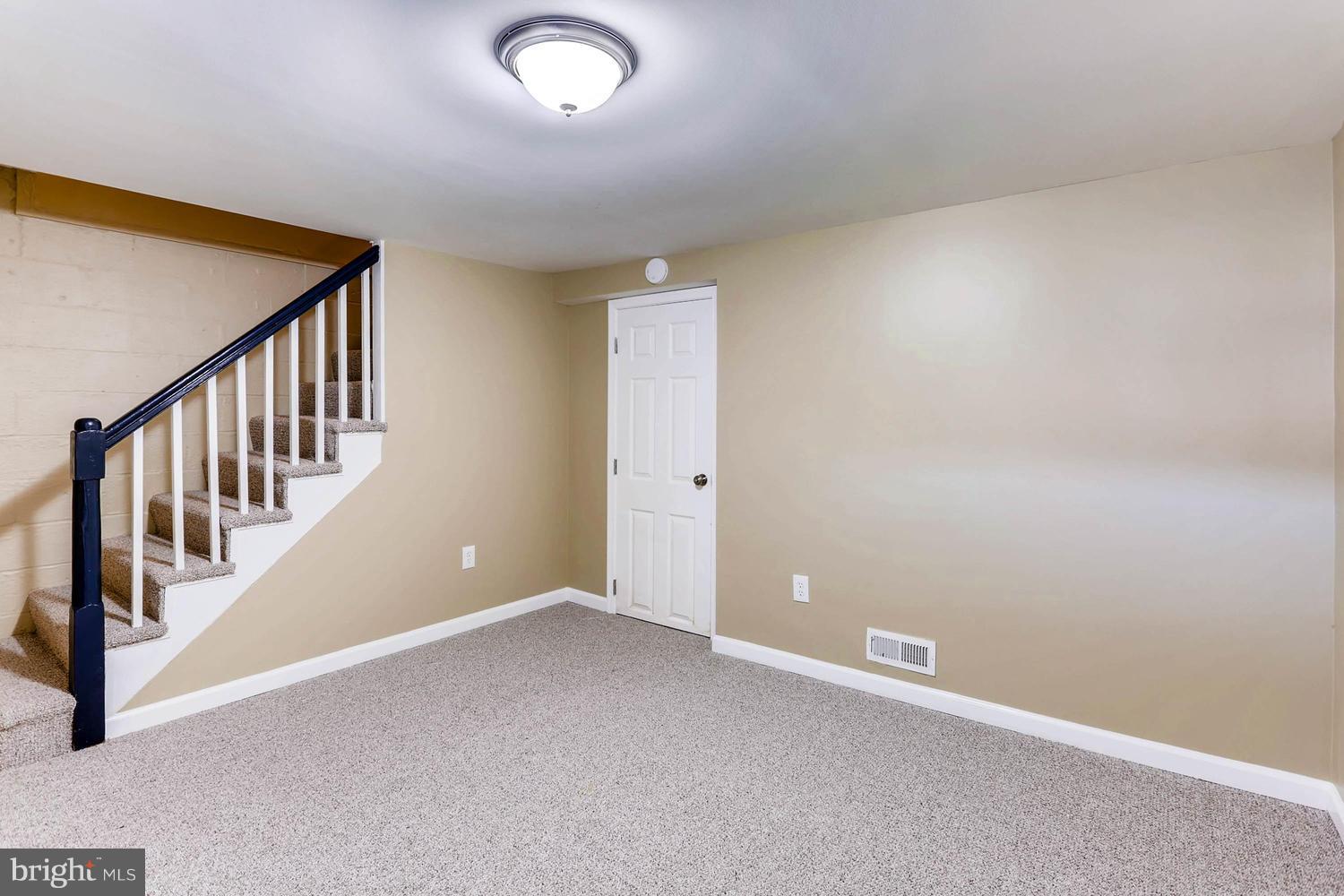 7530 Westfield Road Baltimore, MD 21222 - Photo 23 of 30 an empty room with staircase and white walls