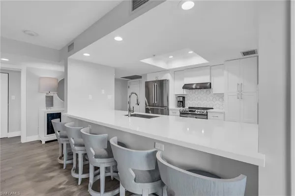 a kitchen with stainless steel appliances a sink a stove a refrigerator and cabinets