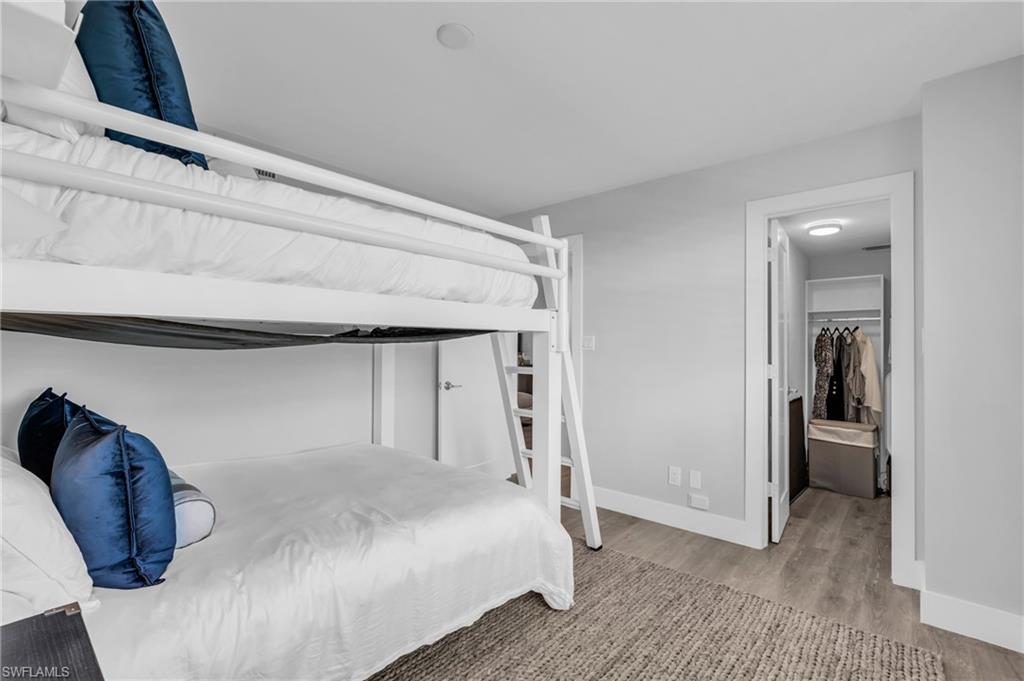 6573 Marissa Loop, Unit 1403 Naples, FL 34108 - Photo 19 of 29 a bedroom with a bed and a mirror