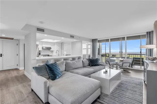 a living room with furniture and view of kitchen
