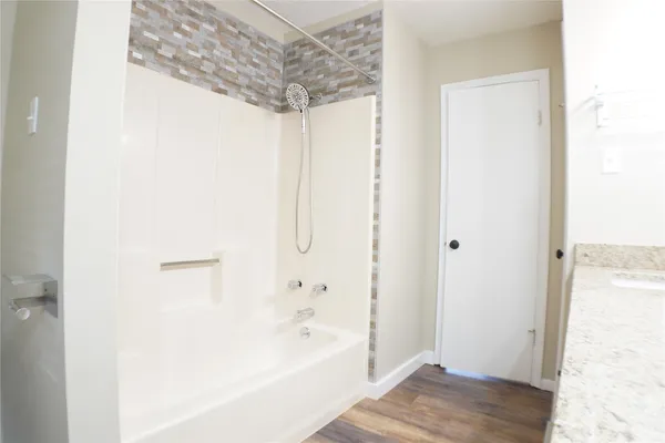 a bathroom with a granite countertop sink a mirror and a shower
