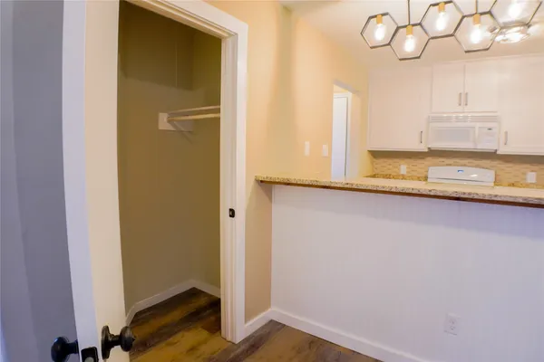 a kitchen with cabinets appliances and wooden floor