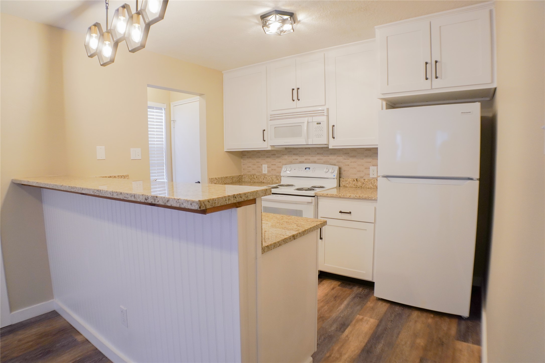 2401 Sycamore Avenue, Unit B2 Huntsville, TX 77340 - Photo 6 of 17 a kitchen with cabinets appliances and wooden floor