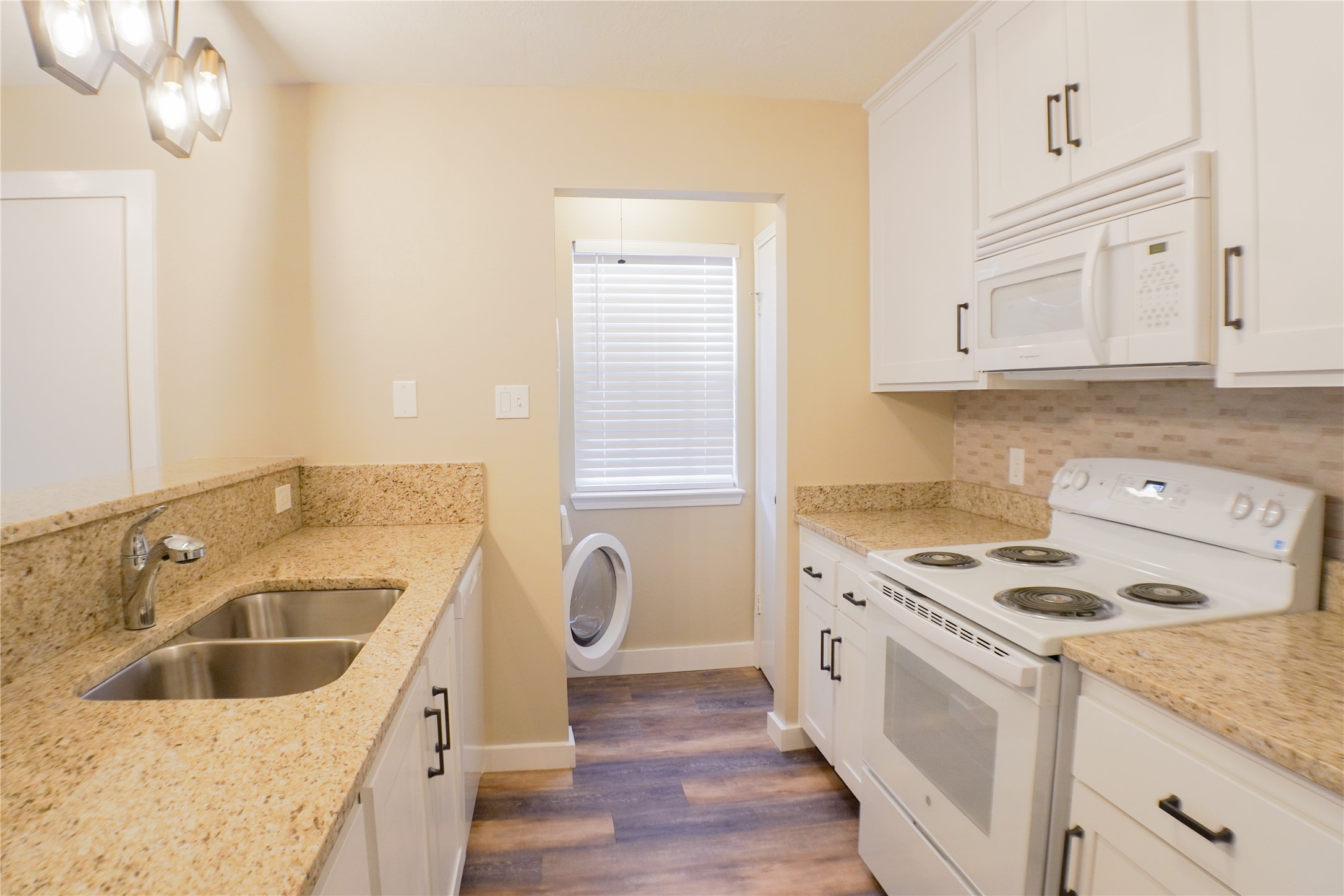 2401 Sycamore Avenue, Unit B2 Huntsville, TX 77340 - Photo 7 of 17 a kitchen with a sink stove top oven and cabinets
