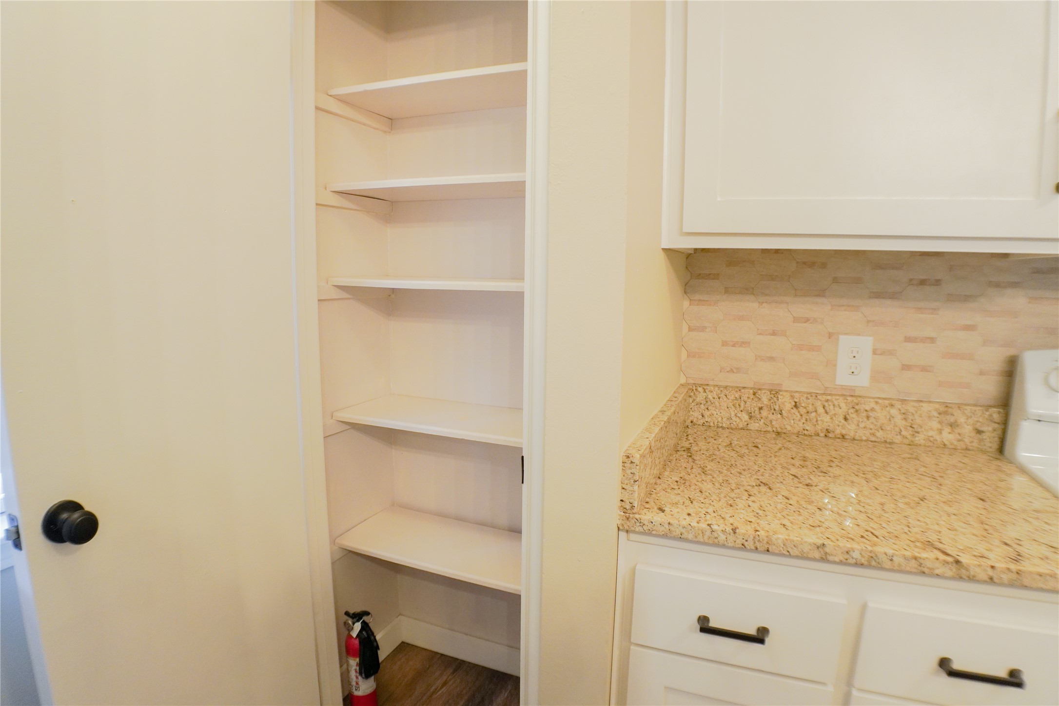 2401 Sycamore Avenue, Unit B2 Huntsville, TX 77340 - Photo 10 of 17 a bathroom with a granite countertop sink and white cabinets