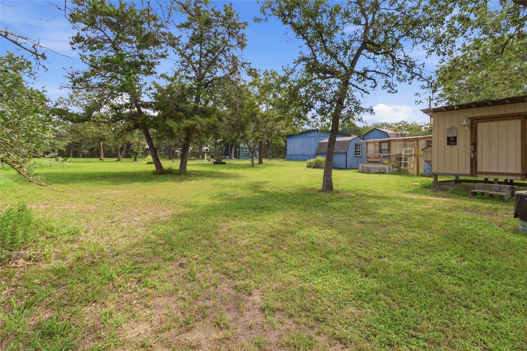 7921 Vista Ranch Road Smithville, TX 78957 - Photo 27 of 39 A verdant, tree-dotted lot with charming outbuildings offers ample space for outdoor living.