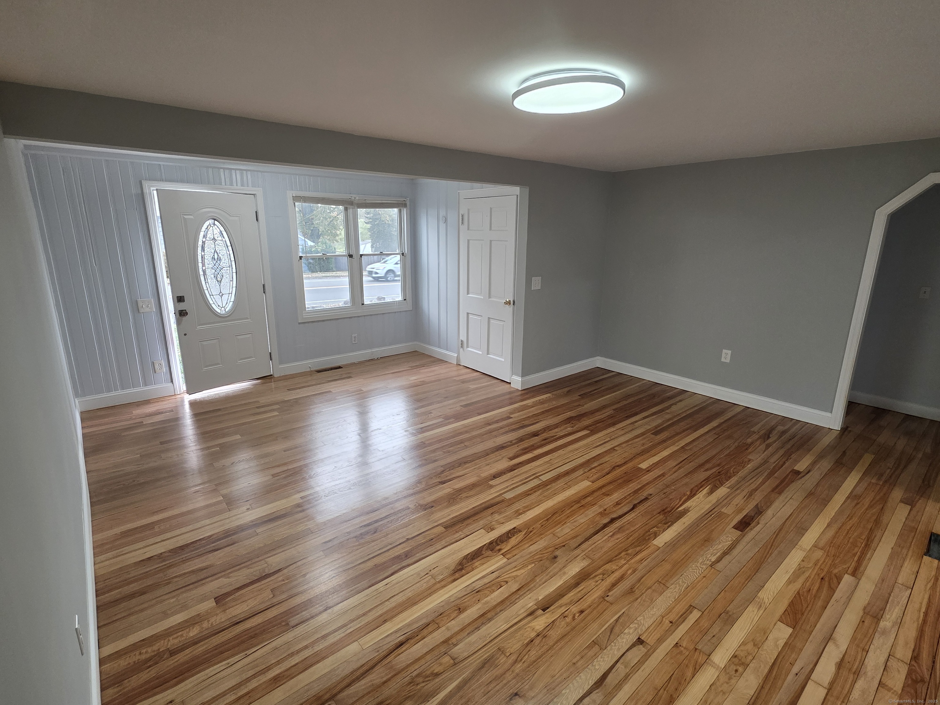 62 Pond Point Avenue Milford, CT 06460 - Photo 3 of 15 an empty room with wooden floor and windows