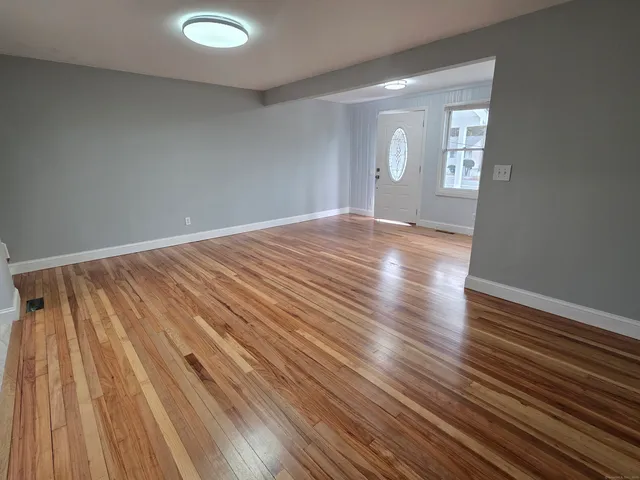 wooden floor in an empty room with a window