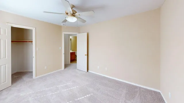 an empty room with a ceiling fan and a window