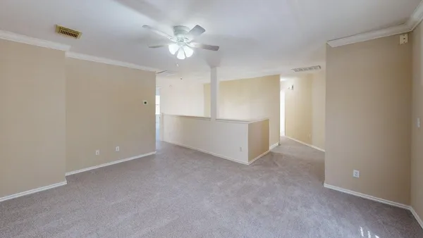 an empty room with a window and a ceiling fan