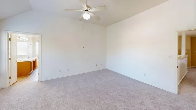 an empty room with a window and a ceiling fan
