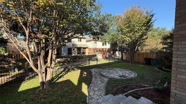 a view of a yard with plants and trees
