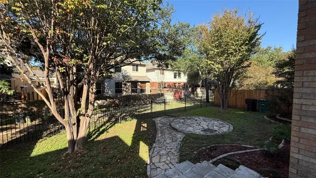 a view of a yard with plants and trees
