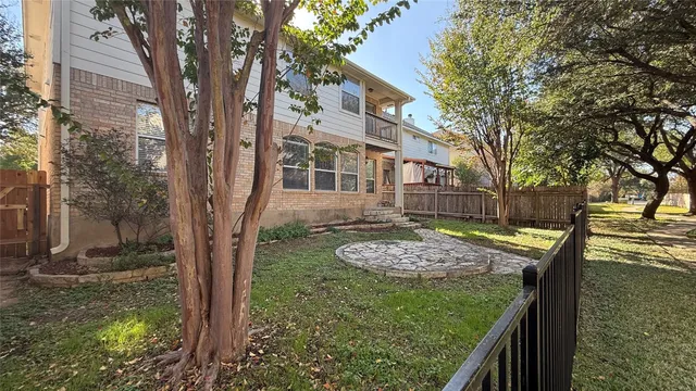 a view of a yard with plants and trees