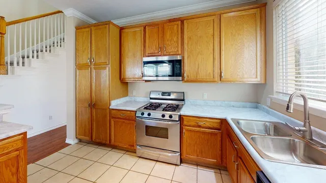 a kitchen with a stove sink and cabinets