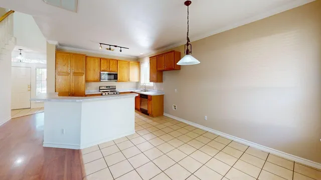 a kitchen with stainless steel appliances granite countertop a sink a stove and a wooden floors