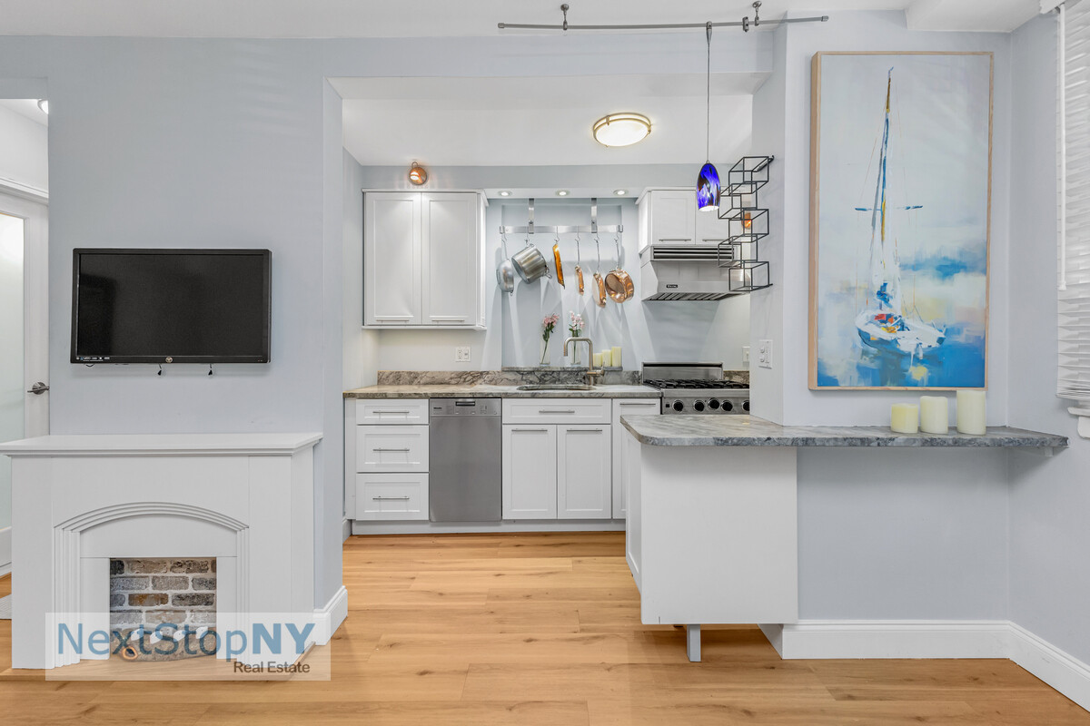 520 East 76th Street, Unit 1F Manhattan, NY 10021 - Photo 4 of 10 a kitchen with stainless steel appliances granite countertop a stove and a microwave