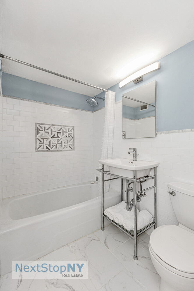 520 East 76th Street, Unit 1F Manhattan, NY 10021 - Photo 6 of 10 a bathroom with a toilet a sink and mirror