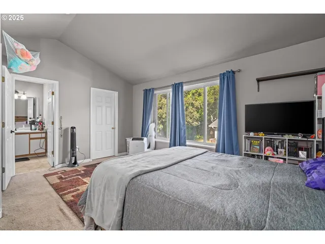 a bedroom with a bed and a flat screen tv