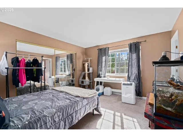 a bedroom with a bed and a large mirror on the dresser