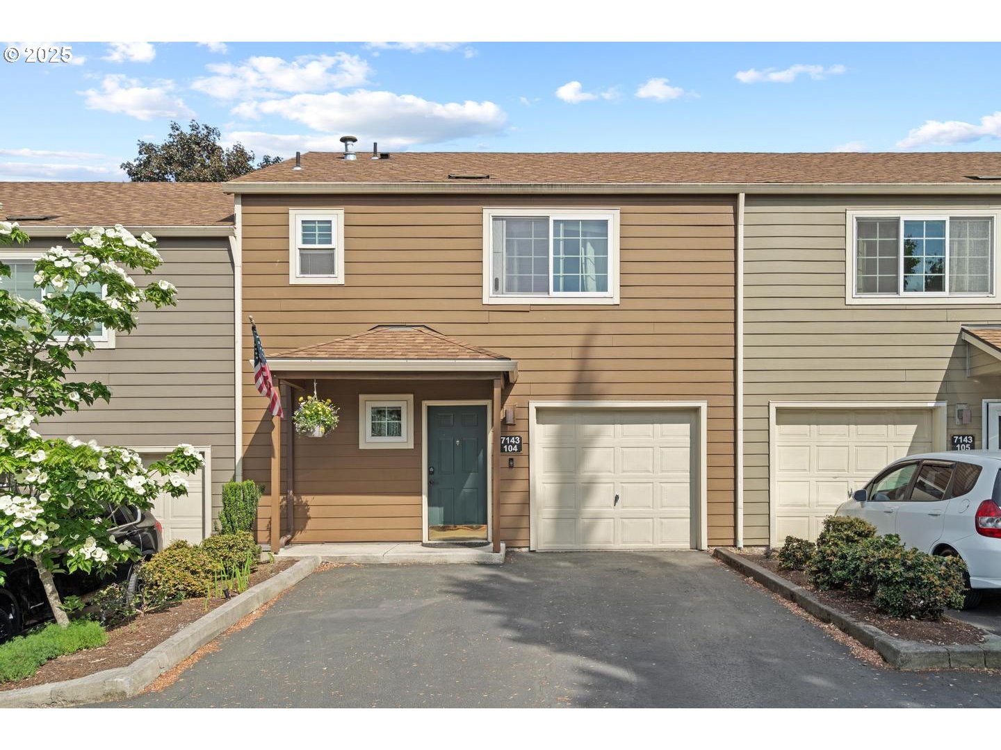 7143 Southwest Sagert Street, Unit 104 Tualatin, OR 97062 - Photo 3 of 33 a front view of a house with a yard and garage