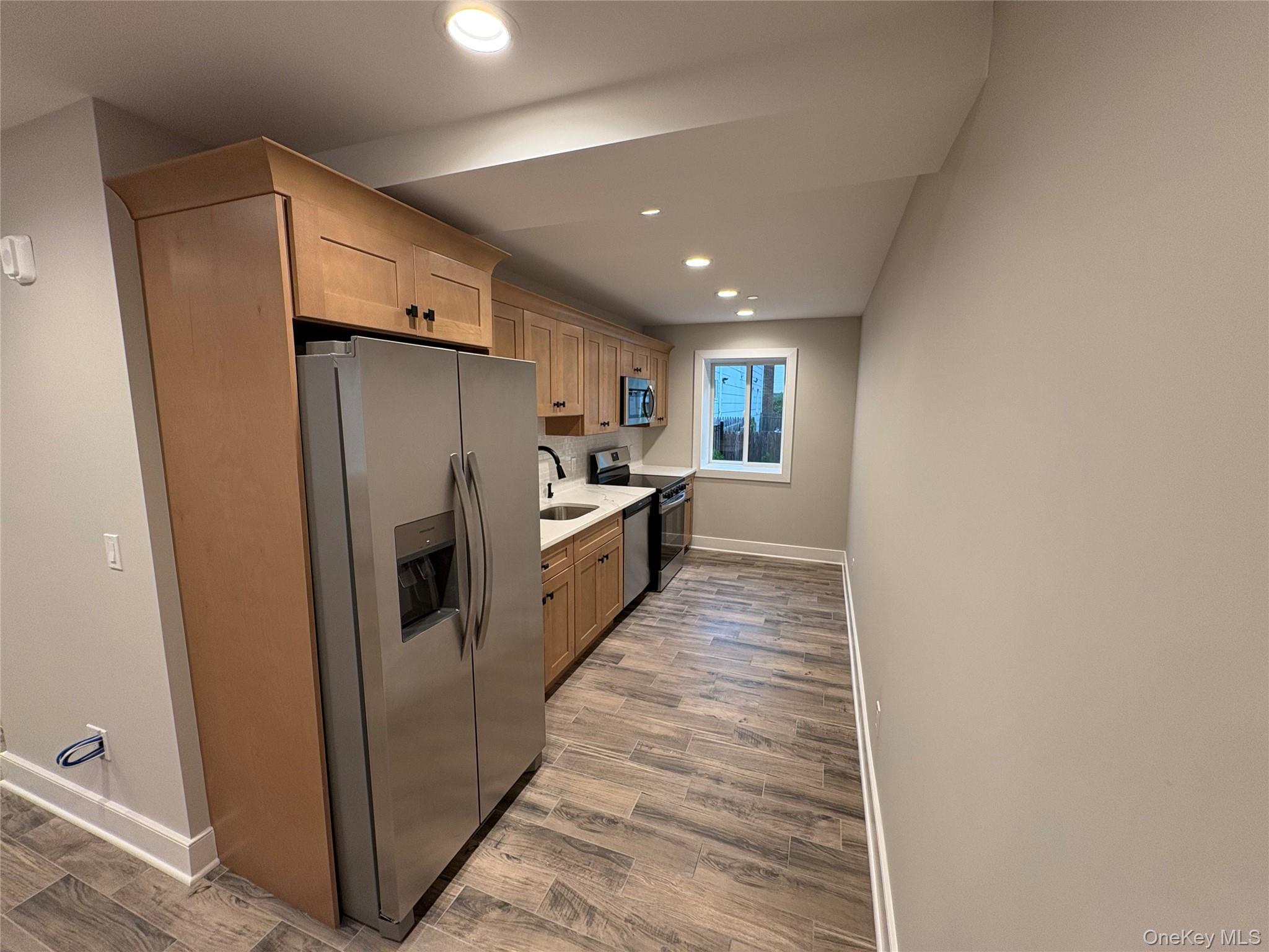 455 Sunrise Highway, Unit 1A West Babylon, NY 11704 - Photo 2 of 15 a kitchen with stainless steel appliances a refrigerator and a stove