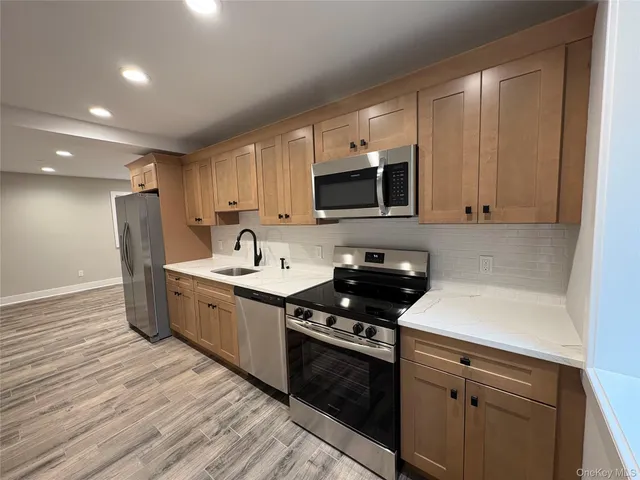 a kitchen with stainless steel appliances a sink dishwasher stove microwave and cabinets