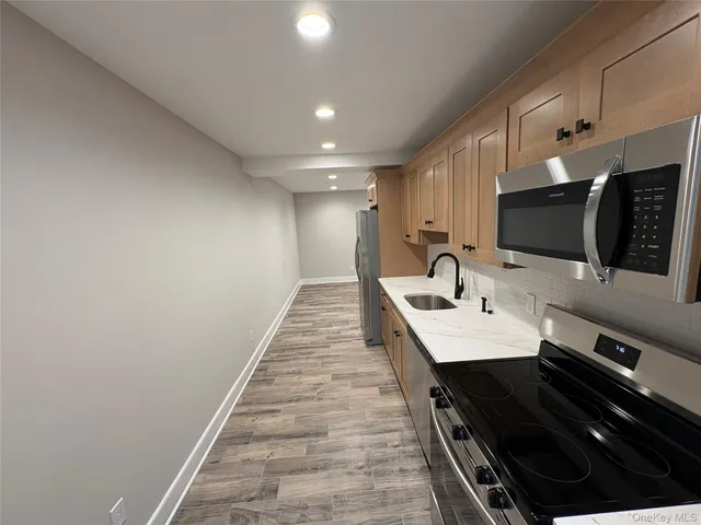 a open kitchen with a sink and stainless steel appliances
