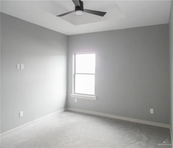 an empty room with a window and a ceiling fan