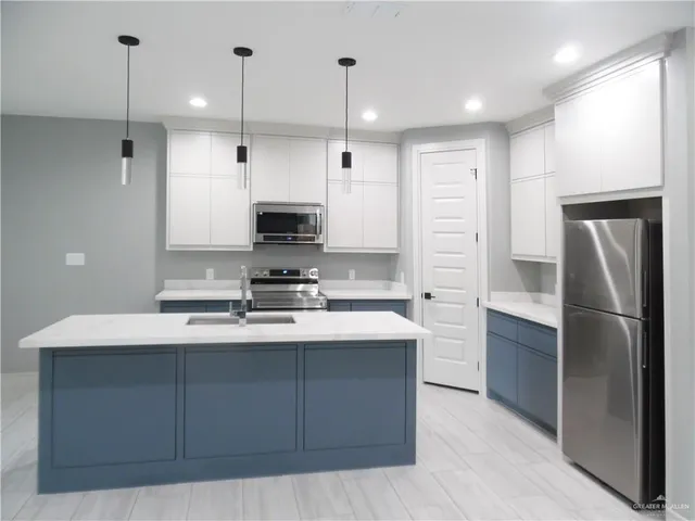 a kitchen with kitchen island a sink stainless steel appliances and cabinets