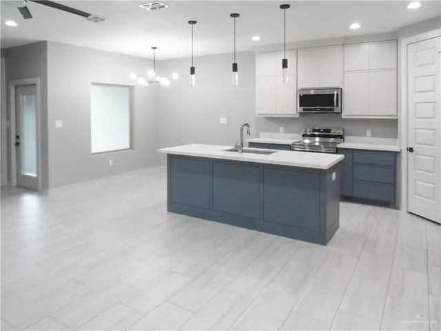 a large kitchen with kitchen island a sink stainless steel appliances and cabinets