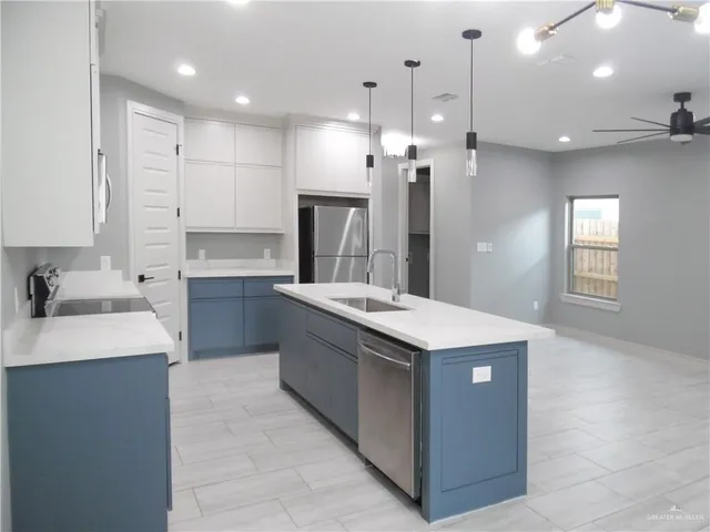a kitchen with kitchen island a sink appliances and cabinets
