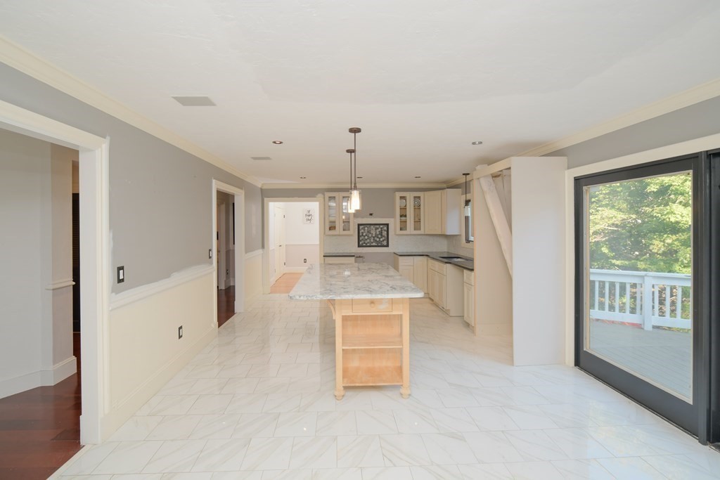885 Randolph Street Canton, MA 02021 - Photo 12 of 40 a large kitchen with a refrigerator a stove a washer dryer and white cabinets