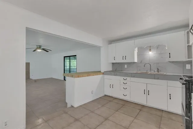 a kitchen with granite countertop white cabinets and sink