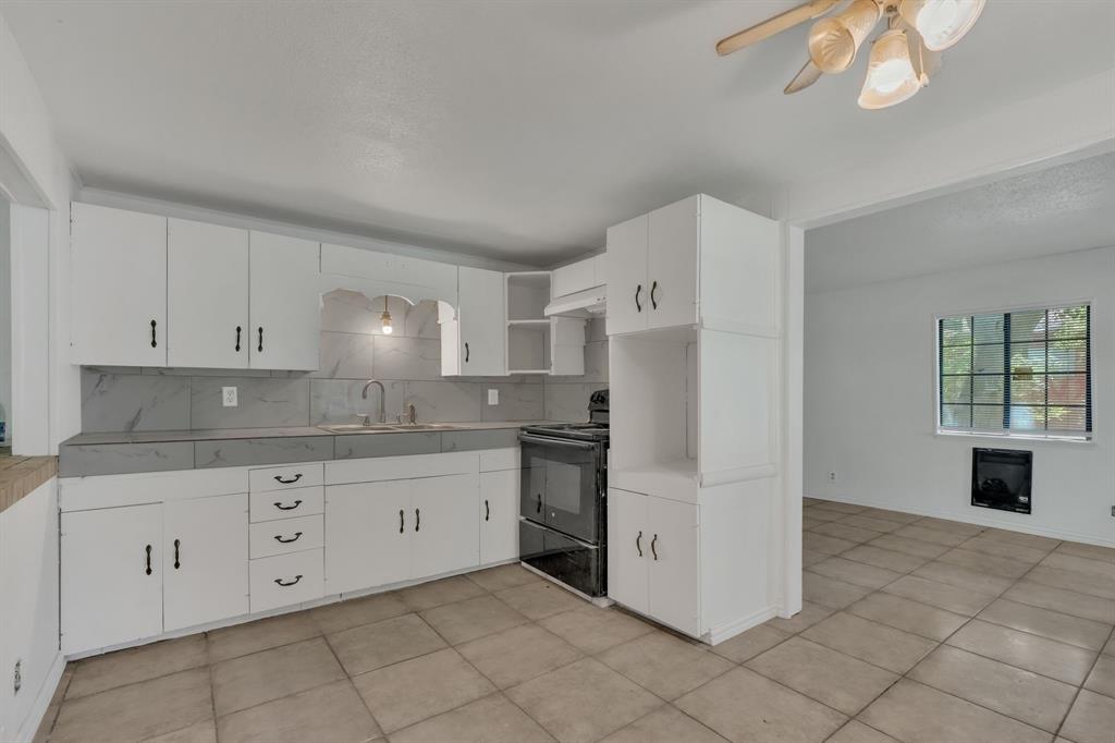 84 Natchez Road Pottsboro, TX 75076 - Photo 7 of 37 a kitchen with granite countertop white cabinets and white appliances