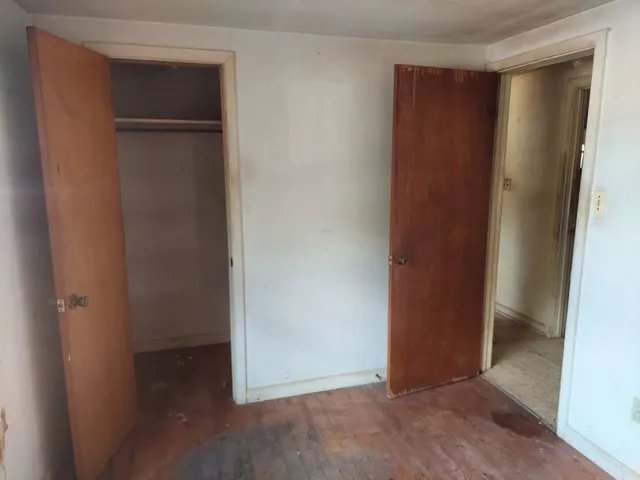 an empty room with closet and wooden door