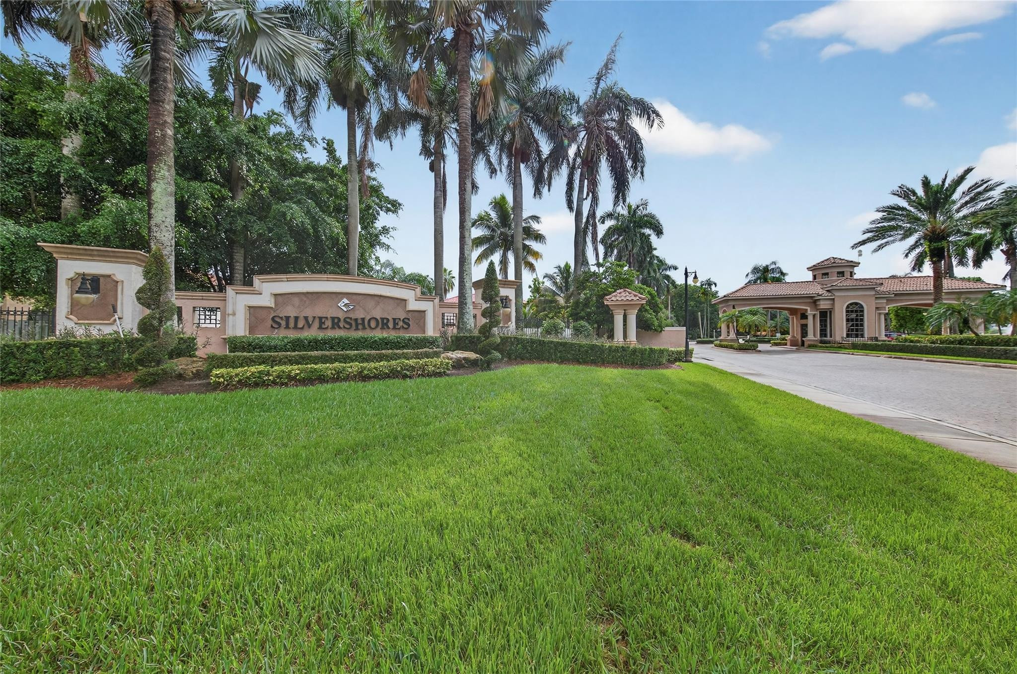 a view of a house with a yard and palm trees
