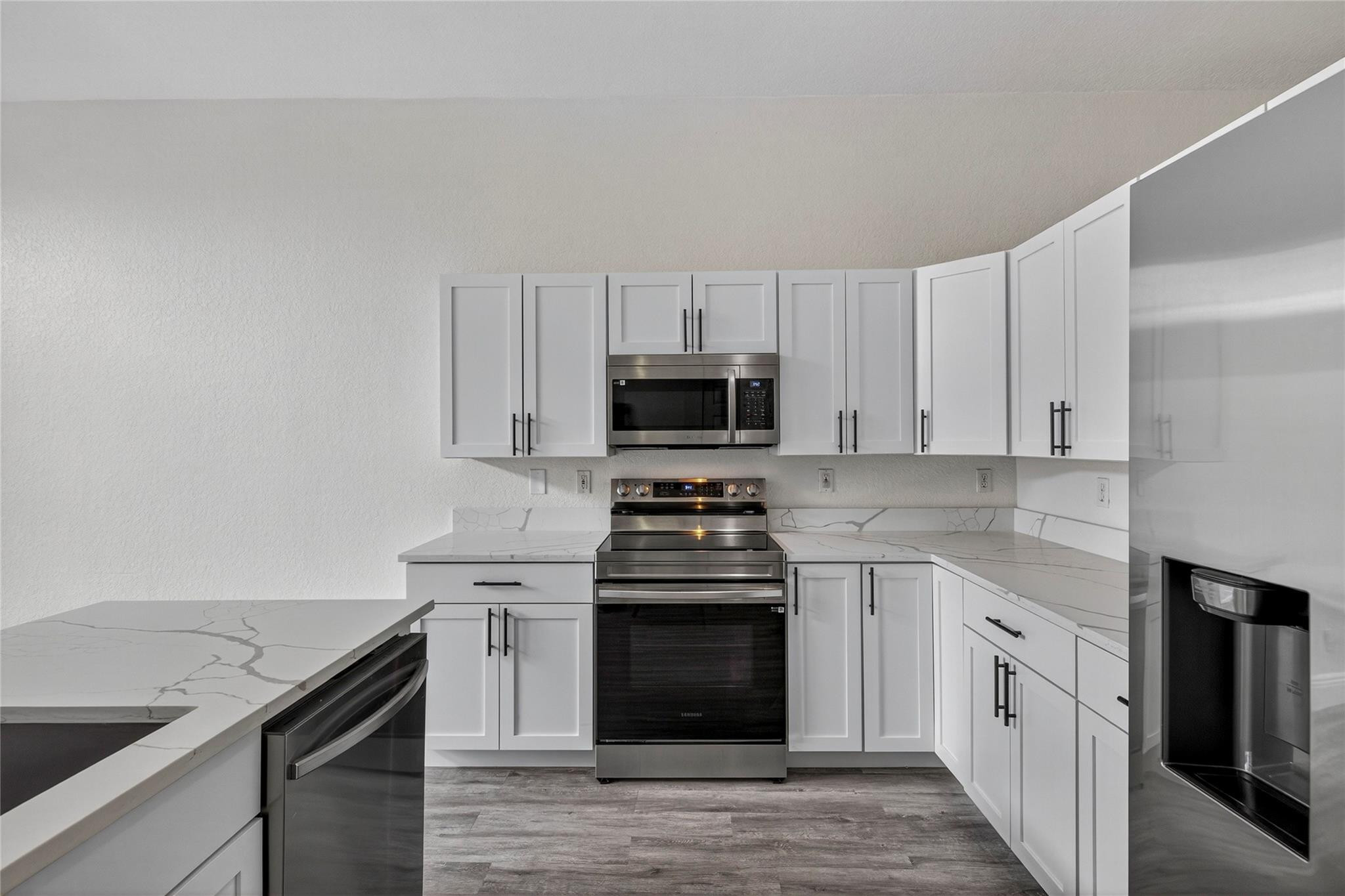 2424 Southwest 162nd Avenue Miramar, FL 33027 - Photo 19 of 44 a kitchen with granite countertop white cabinets and stainless steel appliances