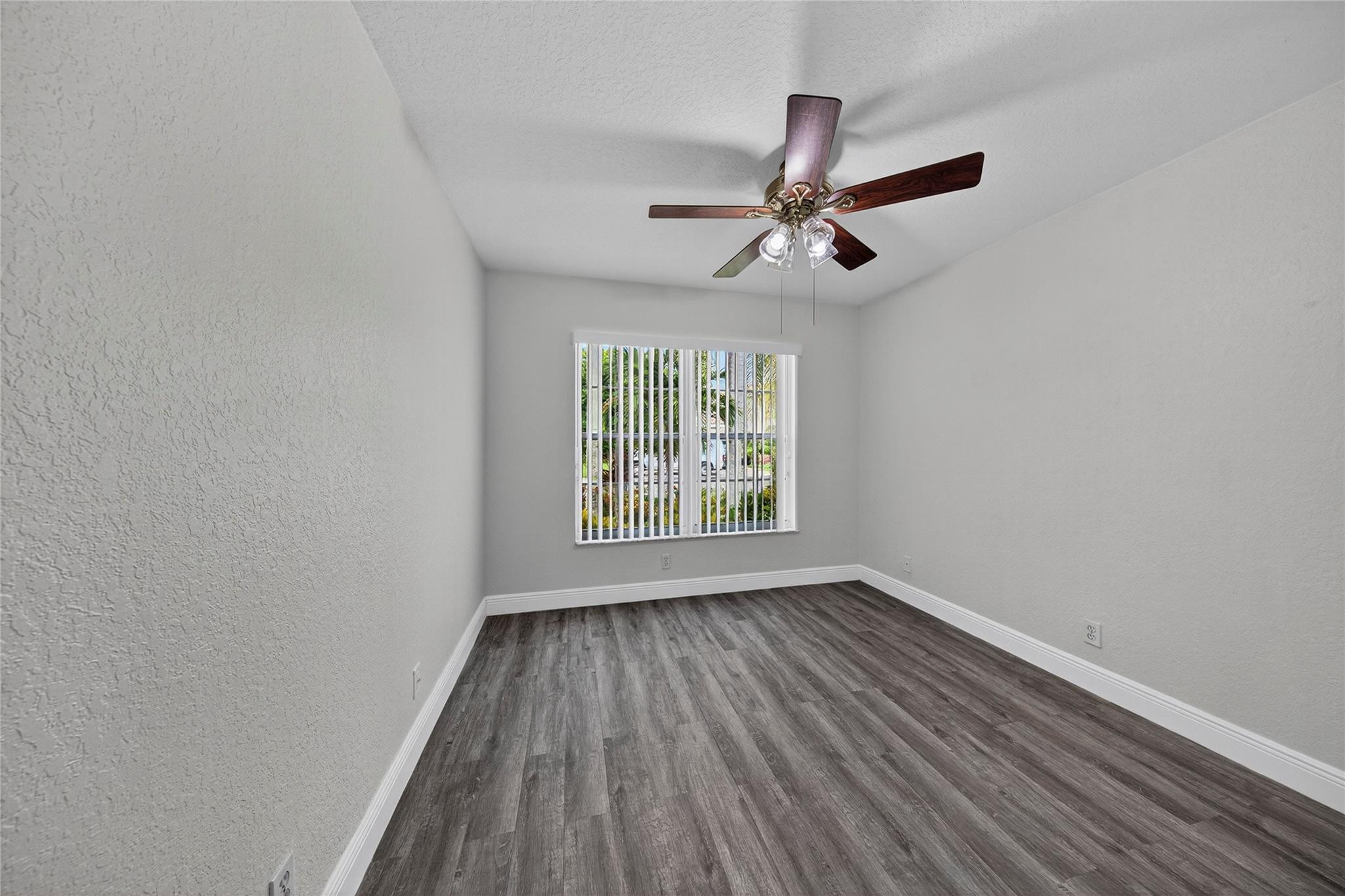 2424 Southwest 162nd Avenue Miramar, FL 33027 - Photo 37 of 44 an empty room with wooden floor ceiling fan and windows